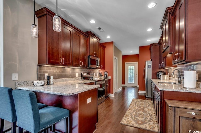 1733 24th Ave N, North Myrtle Beach, SC 29582 - kitchen featuring appliances with stainless steel finishes, a peninsula, tasteful backsplash, light stone countertops, and recessed lighting