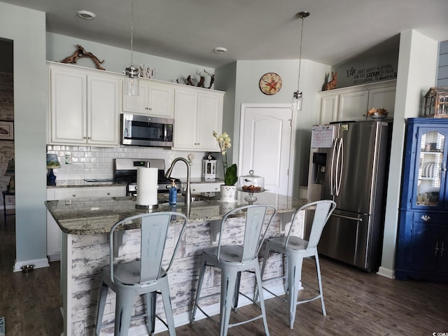 2256 Heritage Loop Unit 2256, Myrtle Beach, SC 29577 - kitchen featuring stainless steel appliances, dark stone counters, backsplash, a breakfast bar, and dark wood-style floors