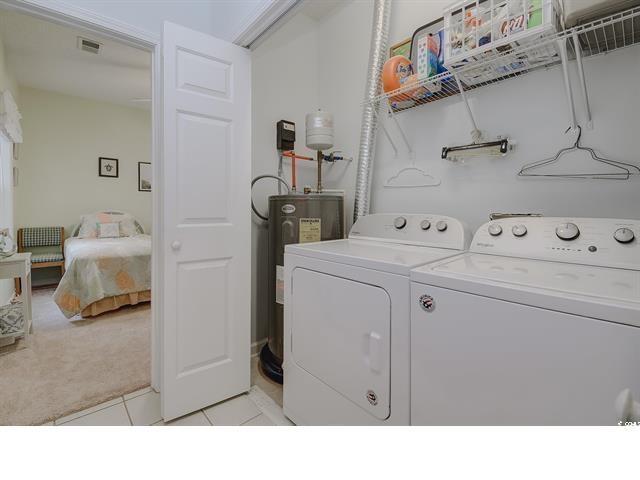 1058 Sea Mountain Hwy Unit 10-101, North Myrtle Beach, SC 29582 - laundry area featuring washer and clothes dryer, light carpet, electric water heater, and light tile patterned flooring