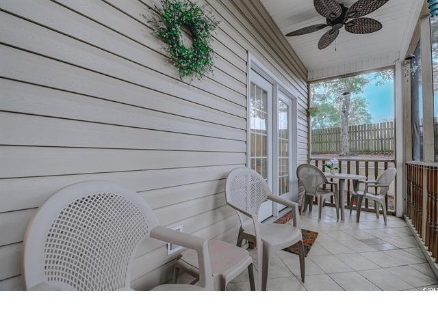 1058 Sea Mountain Hwy Unit 10-101, North Myrtle Beach, SC 29582 - sunroom / solarium with ceiling fan, tile patterned flooring, outdoor dining area, and wooden walls