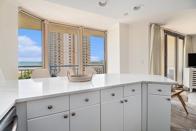 8560 Queensway Blvd Unit 706, Myrtle Beach, SC 29572 - kitchen featuring wood finished floors, white cabinets, light stone countertops, a water view, and recessed lighting