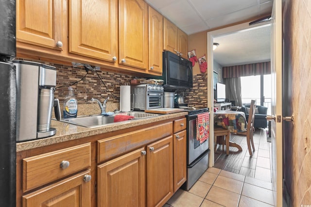 6804 N Ocean Blvd Unit 515, Myrtle Beach, SC 29572 - kitchen featuring black microwave, light countertops, backsplash, light tile patterned floors, and stainless steel range with electric stovetop