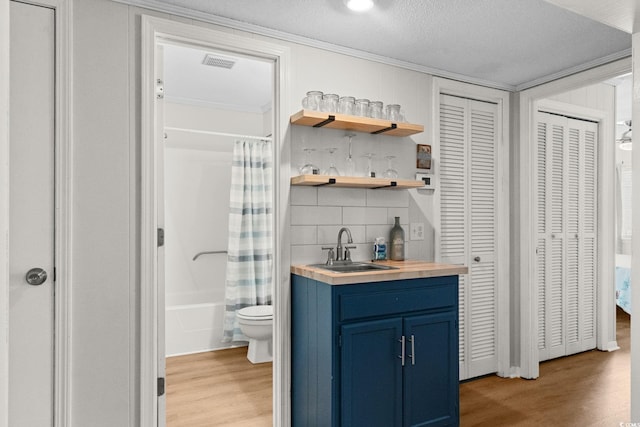 6001 N Ocean Blvd Unit 137, North Myrtle Beach, SC 29582 - indoor wet bar with light wood-style floors, decorative backsplash, and crown molding