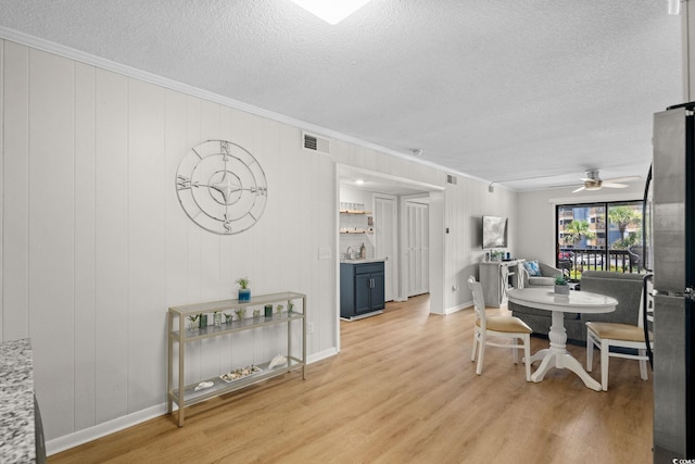 6001 N Ocean Blvd Unit 137, North Myrtle Beach, SC 29582 - dining area with a textured ceiling, crown molding, light wood-type flooring, and ceiling fan