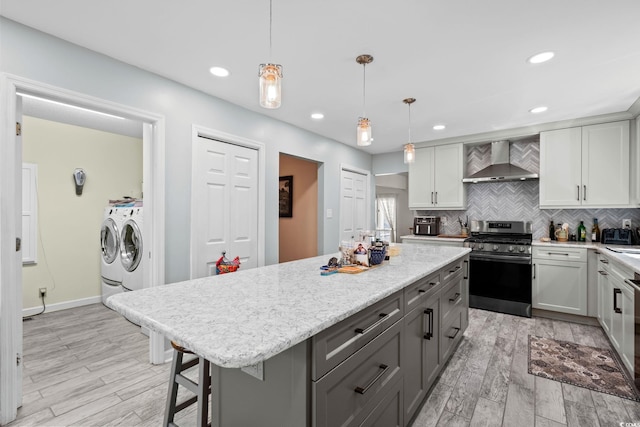 528 George Washington Trl, Georgetown, SC 29440 - kitchen with separate washer and dryer, wall chimney range hood, gas stove, gray cabinetry, and backsplash