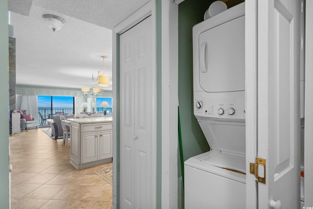 517 S Ocean Blvd Unit 705, North Myrtle Beach, SC 29582 - washroom with estacked washer and dryer, a textured ceiling, and light tile patterned floors