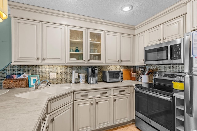 517 S Ocean Blvd Unit 705, North Myrtle Beach, SC 29582 - kitchen with stainless steel appliances, decorative backsplash, a textured ceiling, glass insert cabinets, and ornamental molding