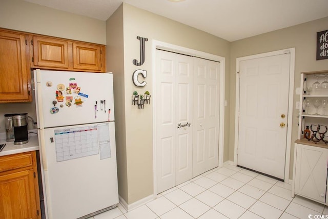 654 Blue Bird Ln, Murrells Inlet, SC 29576 - kitchen with freestanding refrigerator, light countertops, brown cabinetry, and light tile patterned floors
