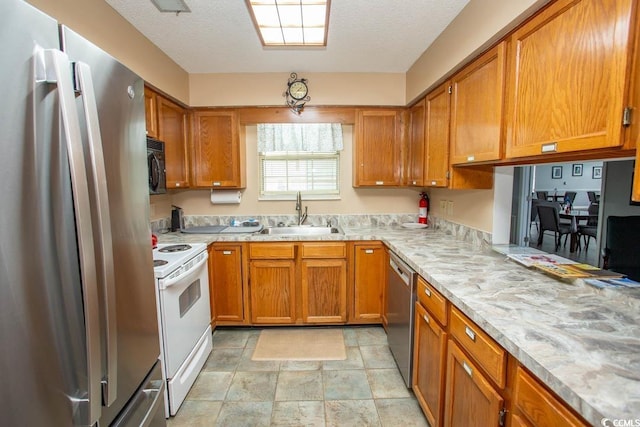 654 Blue Bird Ln, Murrells Inlet, SC 29576 - kitchen with stainless steel appliances, brown cabinets, stone finish flooring, and a textured ceiling