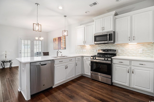 4051 Mclamb Ave Unit 4051, Little River, SC 29566 - kitchen with appliances with stainless steel finishes, a peninsula, decorative backsplash, dark wood-style floors, and light countertops