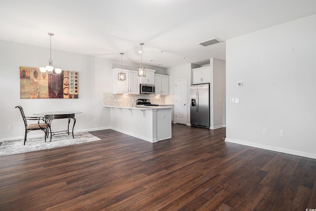 4051 Mclamb Ave Unit 4051, Little River, SC 29566 - kitchen featuring stainless steel appliances, a peninsula, a kitchen bar, light countertops, and dark wood finished floors