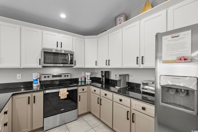 221 N Waccamaw Dr, Murrells Inlet, SC 29576 - kitchen with appliances with stainless steel finishes, light tile patterned floors, dark stone countertops, white cabinets, and recessed lighting