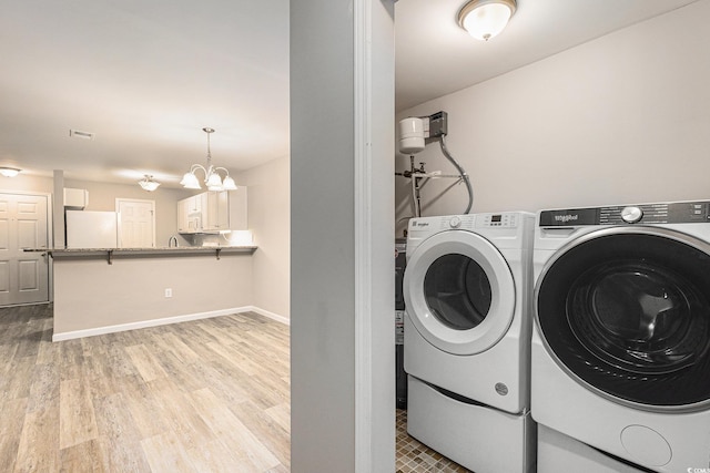 4645 Fringetree Dr Unit 10B, Murrells Inlet, SC 29576 - laundry area featuring independent washer and dryer, light wood-type flooring, and a chandelier