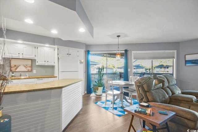 4222 Pinehurst Dr Unit I-9, Little River, SC 29566 - kitchen with freestanding refrigerator, white cabinets, wood finished floors, plenty of natural light, and recessed lighting