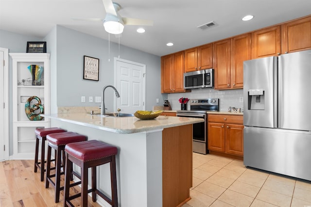 864 Barn Owl Ct Unit 864, Myrtle Beach, SC 29579 - kitchen featuring appliances with stainless steel finishes, a breakfast bar area, brown cabinets, a ceiling fan, and recessed lighting