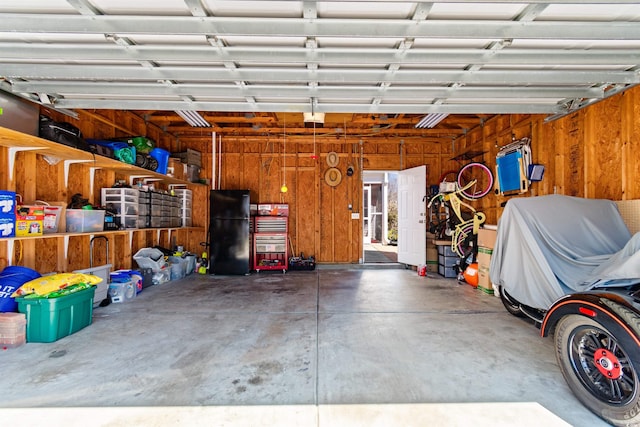 864 Barn Owl Ct Unit 864, Myrtle Beach, SC 29579 - garage with freestanding refrigerator, a garage door opener, and wood walls