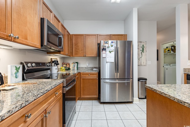 70 Addison Cottage Way Unit 216, Murrells Inlet, SC 29576 - kitchen featuring appliances with stainless steel finishes, washing machine and dryer, light tile patterned floors, and brown cabinets