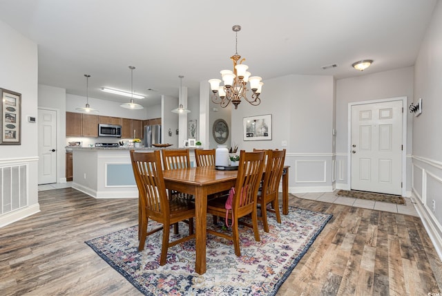70 Addison Cottage Way Unit 216, Murrells Inlet, SC 29576 - dining room with wood finished floors, a chandelier, a wainscoted wall, and a decorative wall
