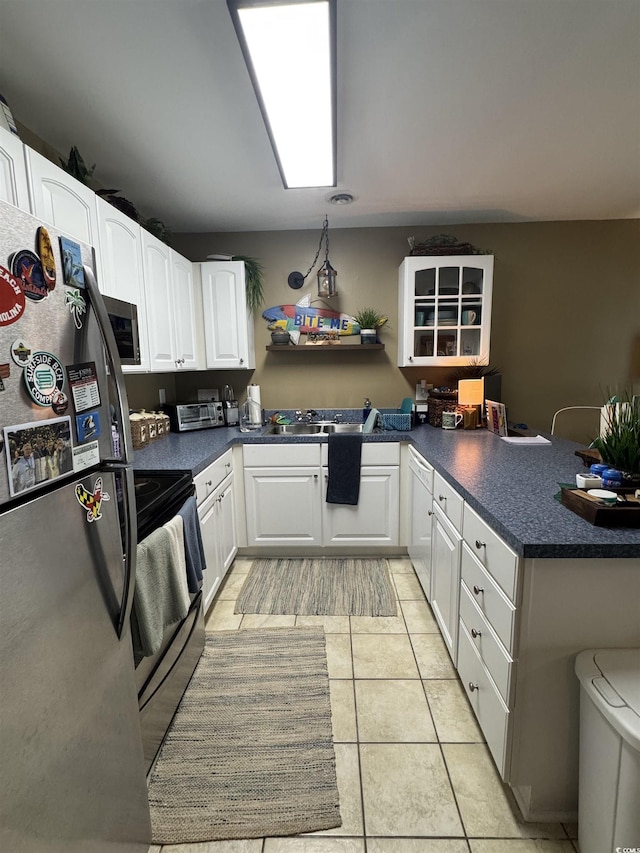 1851 Colony Dr Unit 5M, Surfside Beach, SC 29575 - kitchen featuring stainless steel appliances, a peninsula, dark countertops, white cabinetry, and light tile patterned flooring