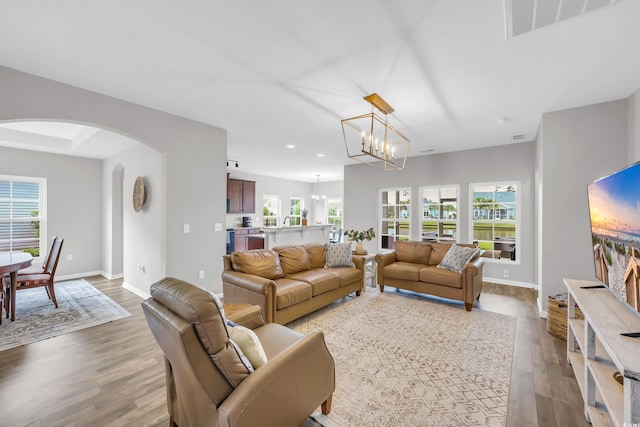 1276 Brighton Hill Ave, Myrtle Beach, SC 29588 - living area featuring arched walkways, wood finished floors, a chandelier, and recessed lighting