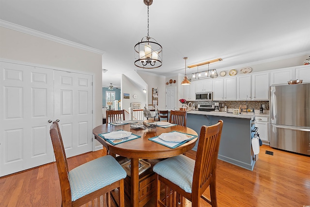 2761 Kruzel St Unit H, Myrtle Beach, SC 29577 - dining area with light wood-type flooring, crown molding, and a chandelier
