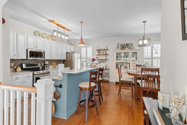 2761 Kruzel St Unit H, Myrtle Beach, SC 29577 - kitchen with stainless steel appliances, healthy amount of natural light, light countertops, light wood-style floors, and ornamental molding