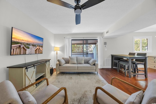 10301 N Kings Hwy Unit 21-4, Myrtle Beach, SC 29572 - living room with wood finished floors, ceiling fan, healthy amount of natural light, and a textured ceiling