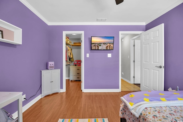 10301 N Kings Hwy Unit 21-4, Myrtle Beach, SC 29572 - bedroom with a walk in closet, ornamental molding, light wood-style flooring, a closet, and ceiling fan