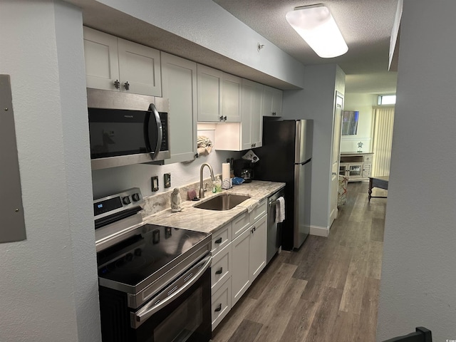 504 Ocean Blvd N Unit 410, Myrtle Beach, SC 29577 - kitchen featuring appliances with stainless steel finishes, dark wood-style floors, a textured ceiling, white cabinets, and a textured wall