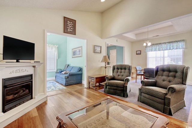 23 Robert Conway Ct, Georgetown, SC 29440 - living room featuring wood finished floors, a chandelier, a glass covered fireplace, lofted ceiling, and recessed lighting