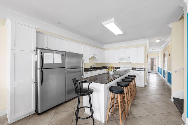817 S Ocean Blvd Unit 201, North Myrtle Beach, SC 29582 - kitchen with white appliances, crown molding, a kitchen bar, dark countertops, and white cabinetry