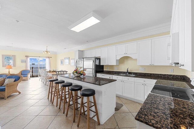 817 S Ocean Blvd Unit 201, North Myrtle Beach, SC 29582 - kitchen featuring freestanding refrigerator, ornamental molding, a center island, a chandelier, and a kitchen bar