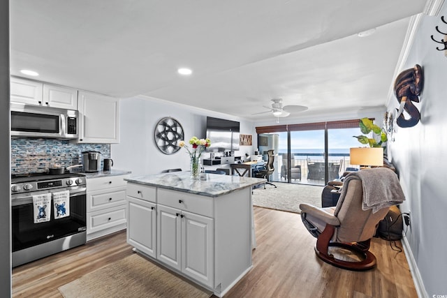 5511 N Ocean Blvd Unit 902, Myrtle Beach, SC 29577 - kitchen with stainless steel appliances, light wood-style flooring, decorative backsplash, white cabinetry, and ceiling fan