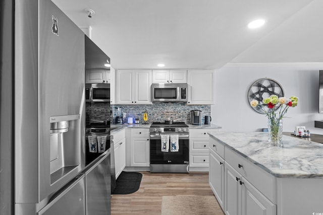5511 N Ocean Blvd Unit 902, Myrtle Beach, SC 29577 - kitchen featuring appliances with stainless steel finishes, tasteful backsplash, light wood finished floors, white cabinetry, and recessed lighting