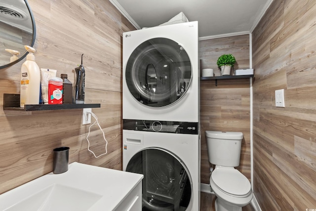 5511 N Ocean Blvd Unit 902, Myrtle Beach, SC 29577 - laundry room with stacked washer / dryer, wood walls, and ornamental molding