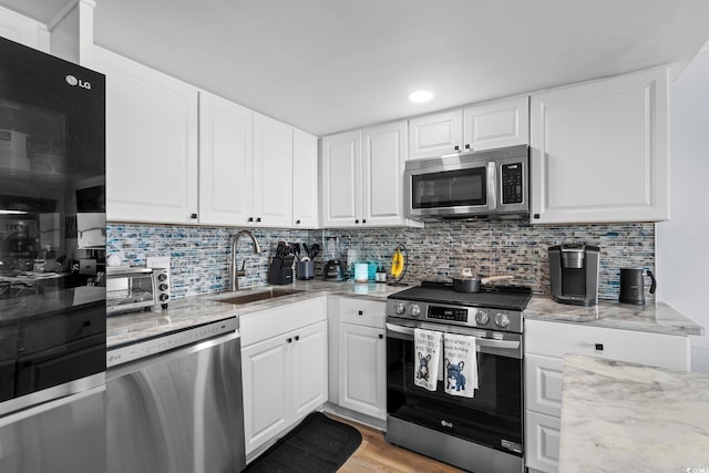 5511 N Ocean Blvd Unit 902, Myrtle Beach, SC 29577 - kitchen with appliances with stainless steel finishes, light stone countertops, white cabinetry, backsplash, and recessed lighting