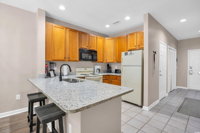 4502 Ailsa Ct Unit B, Conway, SC 29526 - kitchen with white appliances, a peninsula, light stone countertops, a breakfast bar area, and recessed lighting
