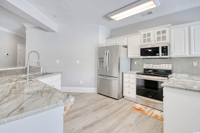 2180 Waterview Dr Unit 721, North Myrtle Beach, SC 29582 - kitchen with appliances with stainless steel finishes, light wood-style floors, tasteful backsplash, white cabinets, and light stone counters