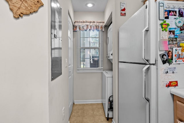 493 White River Dr Unit 28-D, Myrtle Beach, SC 29579 - kitchen featuring freestanding refrigerator, stacked washer / dryer, light tile patterned flooring, and light countertops