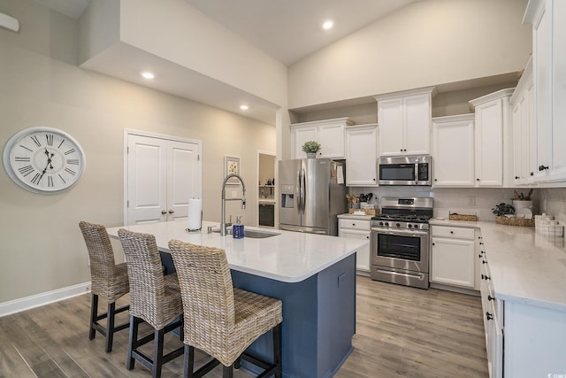 860 Brant St, Myrtle Beach, SC 29579 - kitchen with appliances with stainless steel finishes, high vaulted ceiling, tasteful backsplash, wood finished floors, and white cabinetry