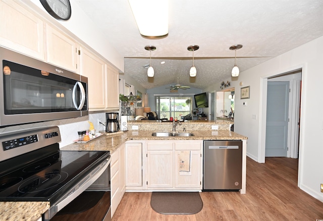 697 Tupelo Ln Unit 24G, Longs, SC 29568 - kitchen with appliances with stainless steel finishes, a peninsula, vaulted ceiling, light wood-style floors, and a ceiling fan