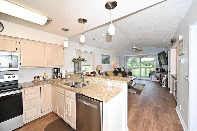 697 Tupelo Ln Unit 24G, Longs, SC 29568 - kitchen featuring stainless steel appliances, a peninsula, vaulted ceiling, open floor plan, and a textured ceiling