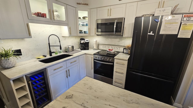 405 21st Ave S Unit 2J, North Myrtle Beach, SC 29582 - kitchen featuring appliances with stainless steel finishes, wine cooler, white cabinets, light stone countertops, and glass insert cabinets