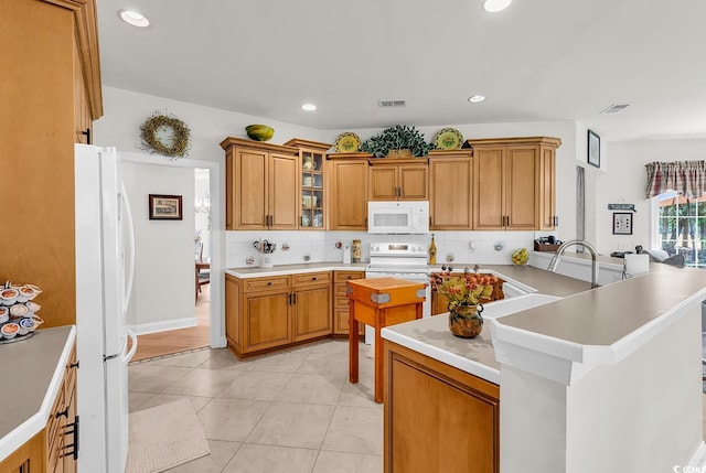 4507 Smilax Pl, Murrells Inlet, SC 29576 - kitchen with white appliances, a peninsula, tasteful backsplash, brown cabinets, and recessed lighting