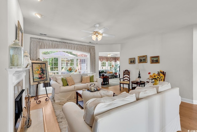4507 Smilax Pl, Murrells Inlet, SC 29576 - living room with a ceiling fan, healthy amount of natural light, a fireplace with flush hearth, and light wood-style floors