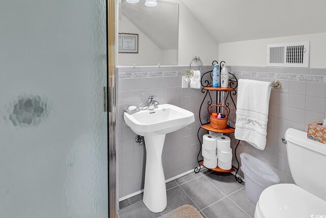 4507 Smilax Pl, Murrells Inlet, SC 29576 - bathroom with tile walls, a shower stall, tile patterned floors, lofted ceiling, and wainscoting