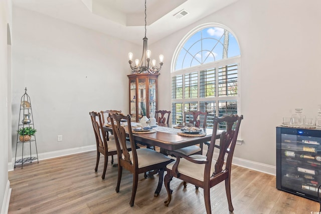 4002 Bayfield Loop, Murrells Inlet, SC 29576 - dining space with wine cooler, a chandelier, light wood finished floors, and a tray ceiling
