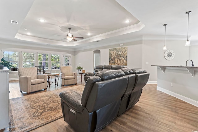 4002 Bayfield Loop, Murrells Inlet, SC 29576 - living area with a tray ceiling, wood finished floors, a ceiling fan, ornamental molding, and arched walkways