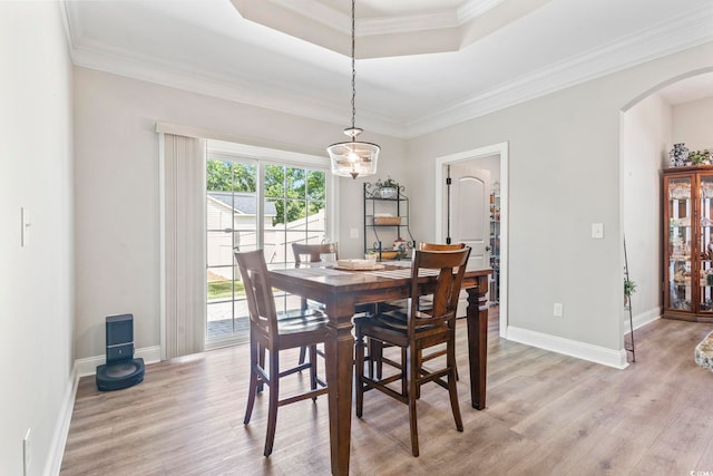 4002 Bayfield Loop, Murrells Inlet, SC 29576 - dining space featuring arched walkways, light wood-style flooring, a chandelier, a raised ceiling, and crown molding
