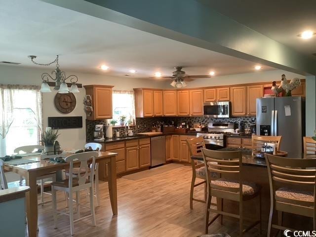 390 Boundary Ave, Murrells Inlet, SC 29576 - kitchen featuring stainless steel appliances, backsplash, dark countertops, light wood-type flooring, and recessed lighting